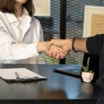 Service business owner and client shaking hands after a booked consultation