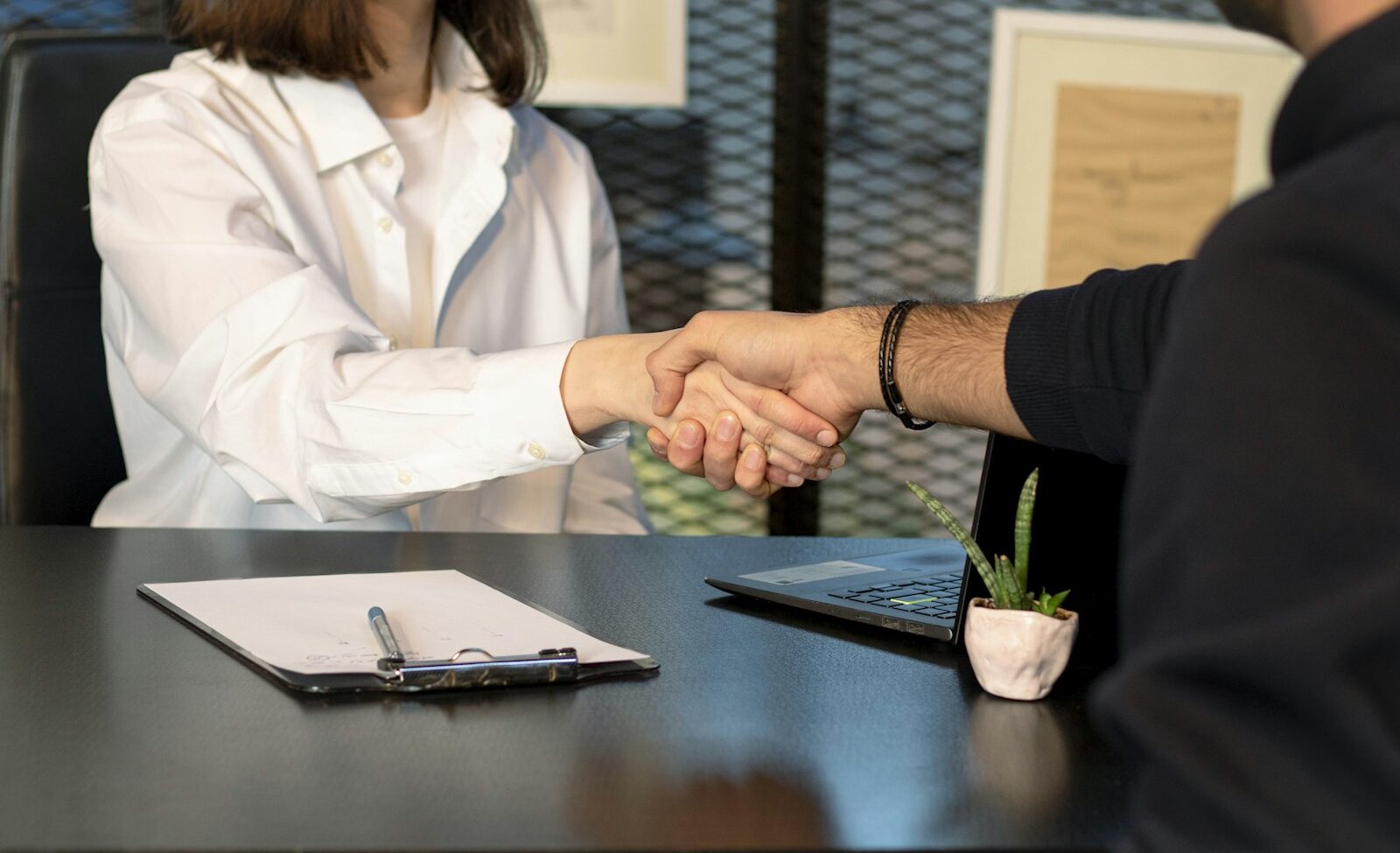 Service business owner and client shaking hands after a booked consultation